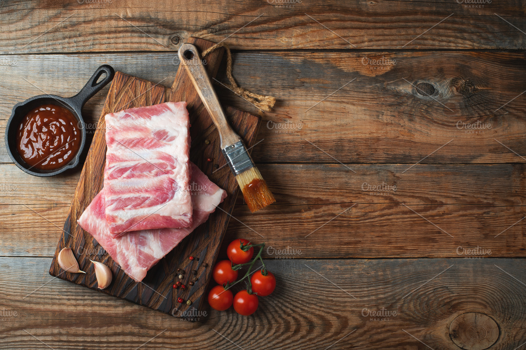 Raw pork ribs with spices, salt and rosemary on dark wooden background, a Food & Drink Photo by Budarinphoto