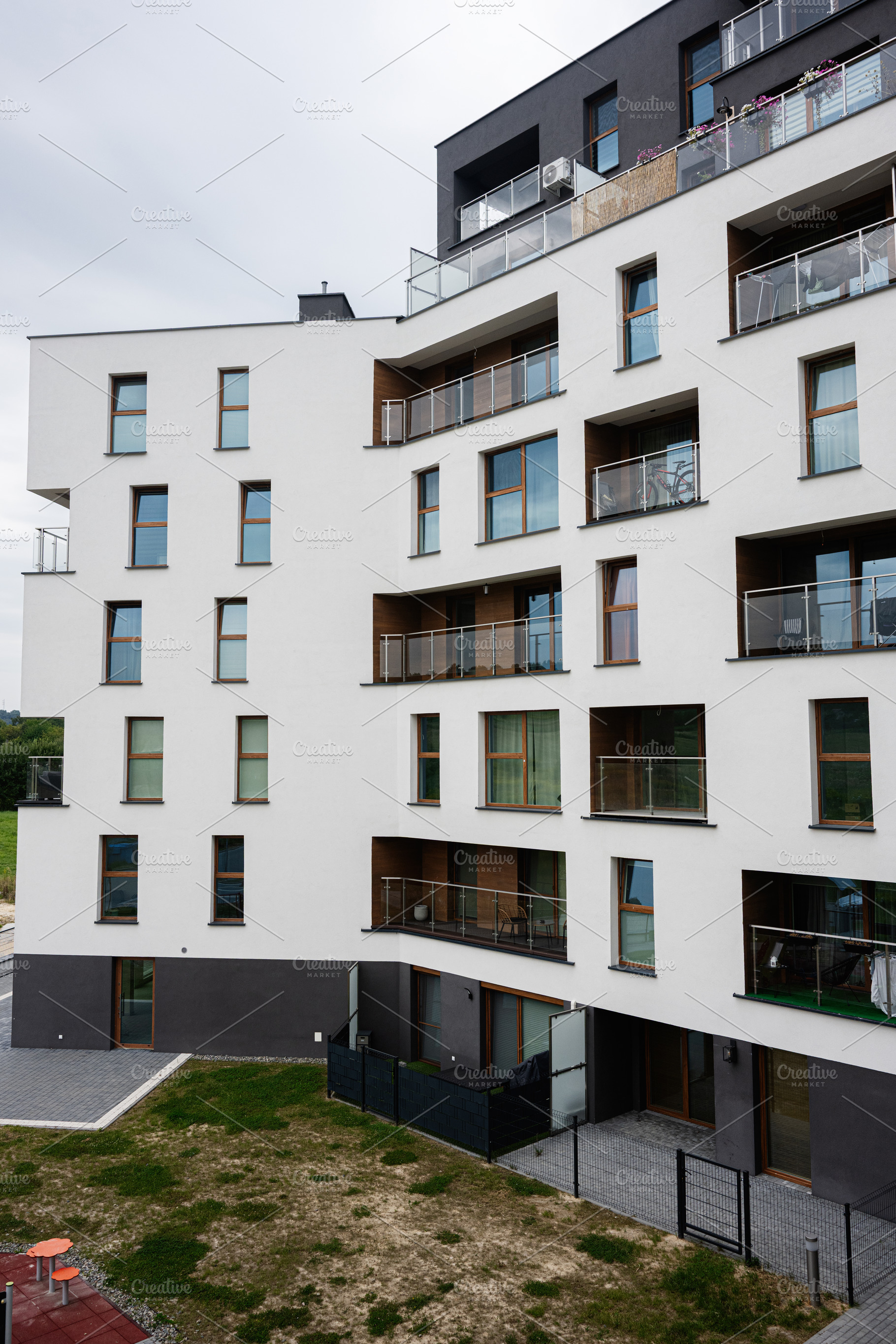 Modern apartment building with balconies  on a cloudy day, a Photo by AS photostudio