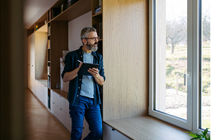 Man standing by the window with, a Person Photo by HalfPoint