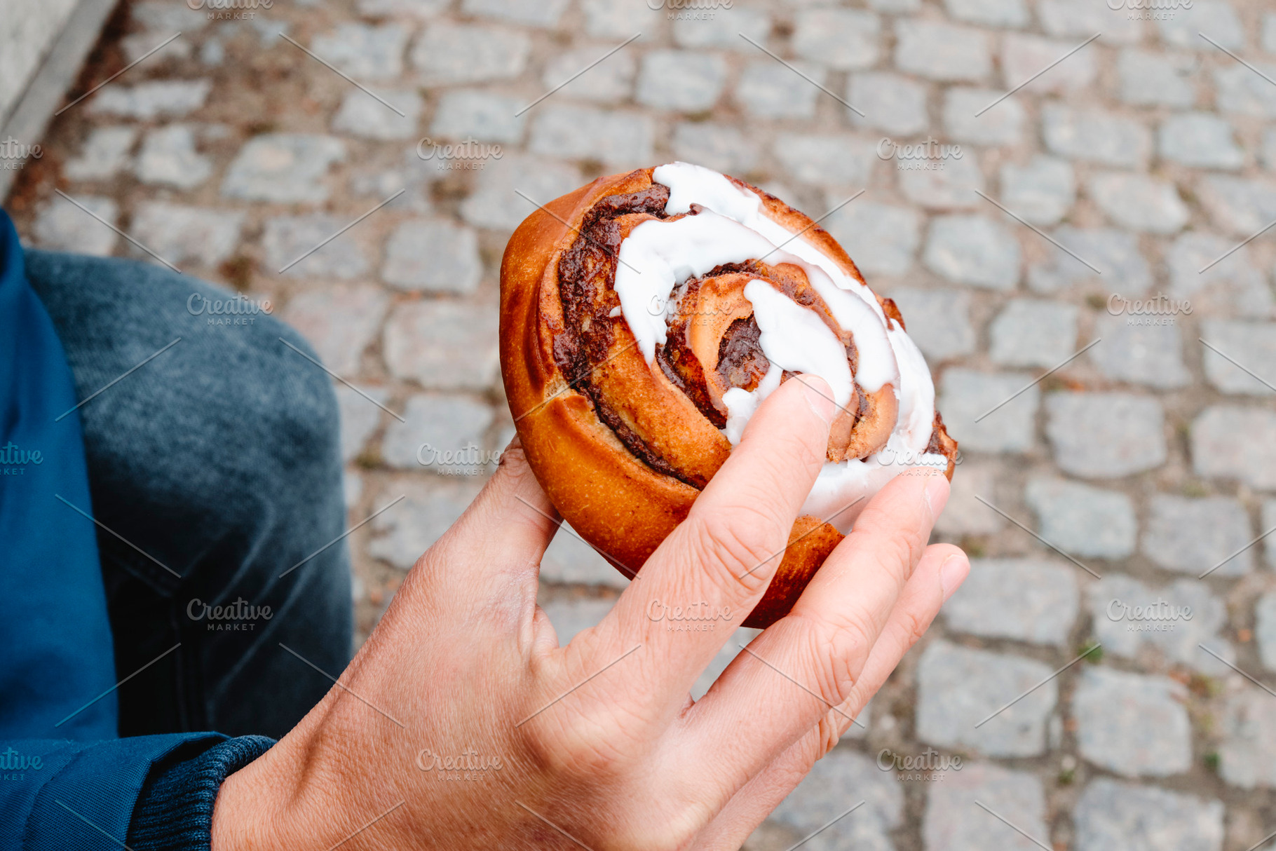 a man holds a traditional kanelsnegl in Copenhagen, a Photo by Nito