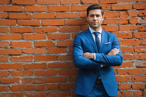 Confident man in blue suit standing, a Photo by Pavel_design