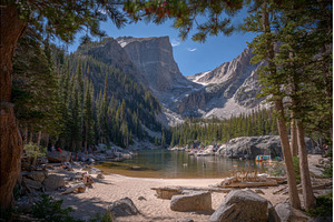A woman hiking sits on the shores of, a Person Photo by ZinetroN