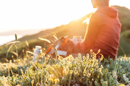 Hiker resting outdoor at sunset. 