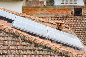 Solar panels with bird protection net on a tiled roof, an Architecture Photo by Antonio Gravante Market
