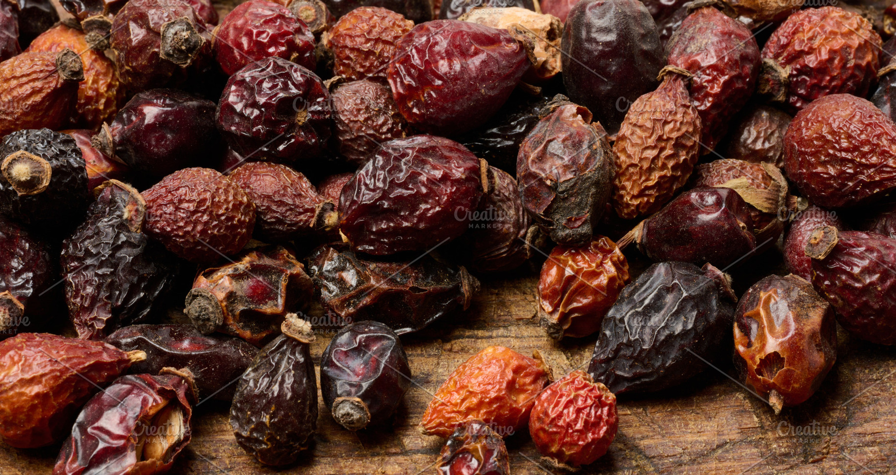 Dried rose hips on a wooden table, close-up., a Food & Drink Photo by ndanko
