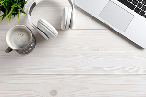 Closed laptop, a wireless headset, and a coffee mug, a Business Photo by DanFLCreativo