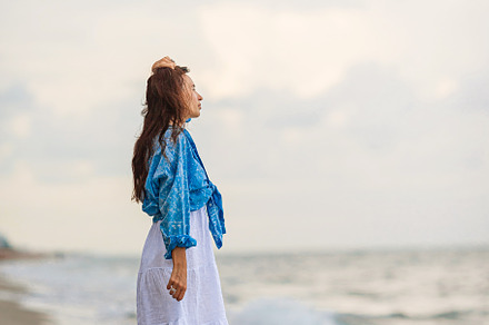 Happy woman enjoying beautiful sunset on the beach