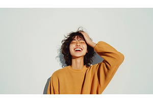 Asian woman laughing joyfully with, a Person Photo by Sergey Kotenev