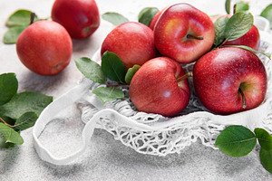 Fresh red apples resting in a reusable shopping bag, a Food & Drink Photo by Olena Rudo