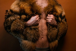 Young man posing in fur coat for pride concept, a Photo by karrastock