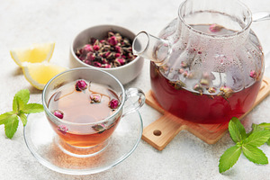 Pouring fragrant rose tea into a transparent cup, a Food & Drink Photo by Olena Rudo