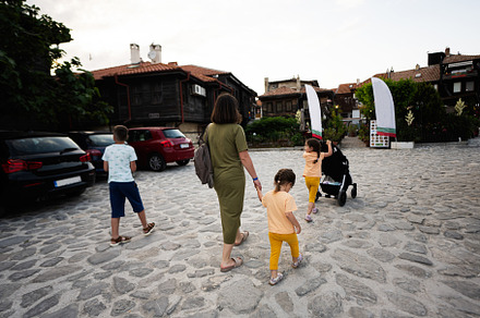 Mother and children walking on the street in the old town of Nes, a Person Photo by AS photostudio