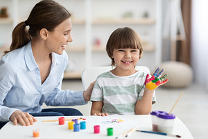 Art classes for children. Happy little boy with colorful painted palm showing h, a Photo by Prostock-Studio