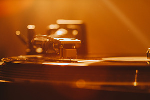 Close up of turntable needle on a vi featuring 70s, 80s, and album