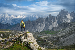 Young woman with backpack on a rock, a Nature Photo by den-belitsky