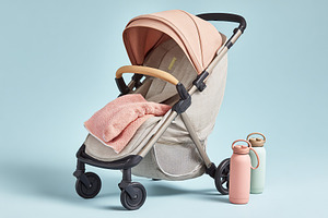 Stylish baby stroller in soft colors with water bottles displayed on a light ba, a Transportation Photo by AlyaAnd