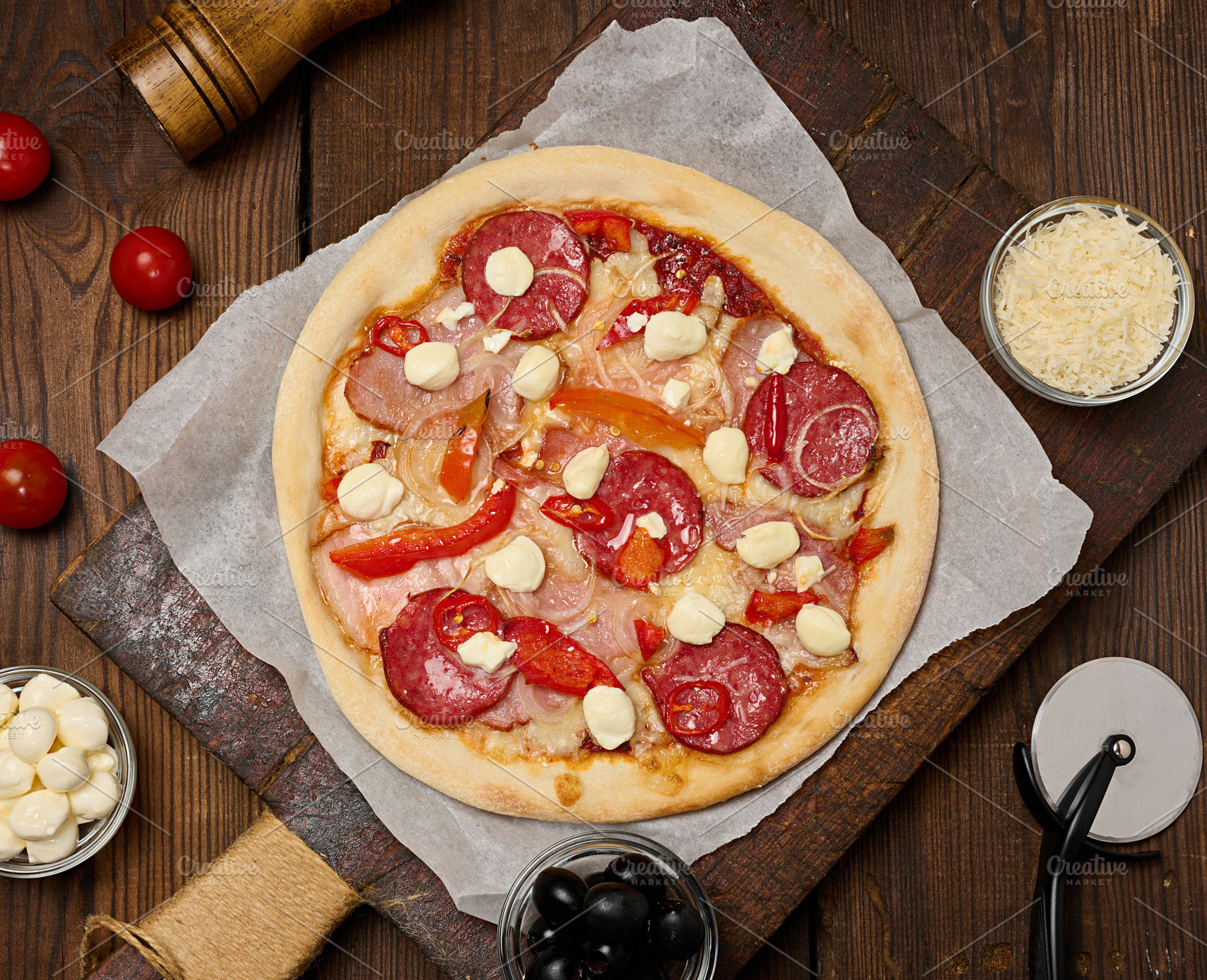 Delicious pizza with salami, ham and mozzarella cheese on parchm, a Food & Drink Photo by ndanko