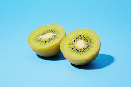 Fresh halved kiwi on a blue backgrou, a Photo by Iftikhar Alam