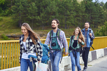 Young people with backpacks stand in stock photo containing friends and, a Person Photo by StudioRomantic