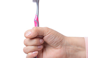 Female hand holding toothbrush on isolated background, a Person Photo by ndanko
