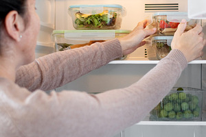 Woman Organizing Healthy Meal Prep Containers in Refrigerator at Home, a Food & Drink Photo by etorres69