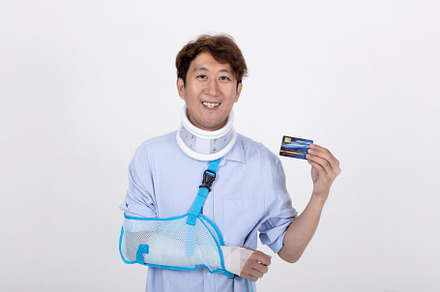 Smiling handsome Asian man with broken arm and neck showing a cr