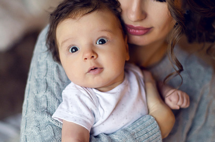 Mom in a sweater holding in his hand containing baby, mother, and son, a Person Photo by SaulichPhoto