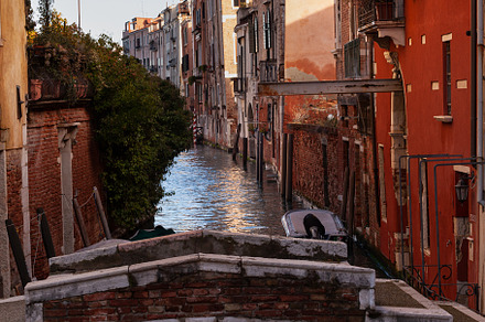 The old bridge made with red bricks on the typical canal in Venice, an Architecture Photo by Bepslabor