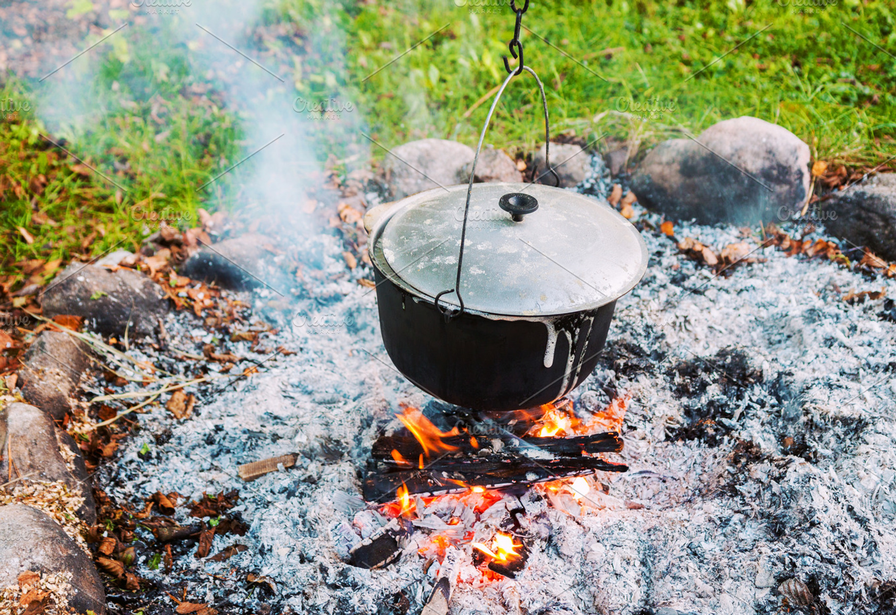 Metal pot over a campfire outdoors, a Food & Drink Photo by BOOCYS
