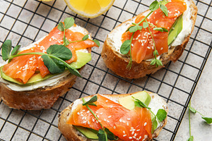 Salmon avocado toasts with microgreens and sesame seeds, a Food & Drink Photo by Olena Rudo