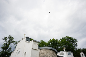Scenic View of Columbarium and Bird Flying Under Cloudy Skies, a Photo by AS photostudio