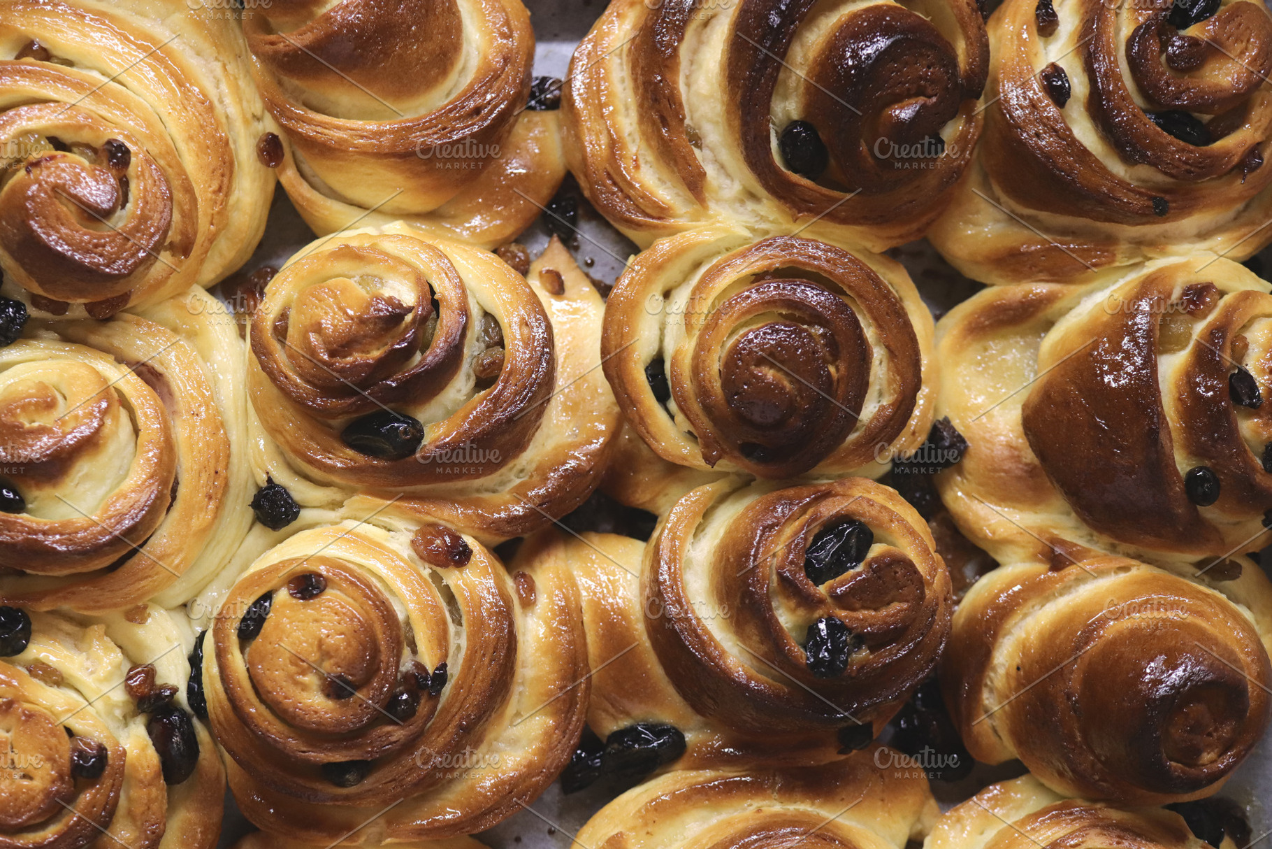 Close-up of freshly baked raisin pastries with golden brown crusts., a Food & Drink Photo by Textures & Backgrounds