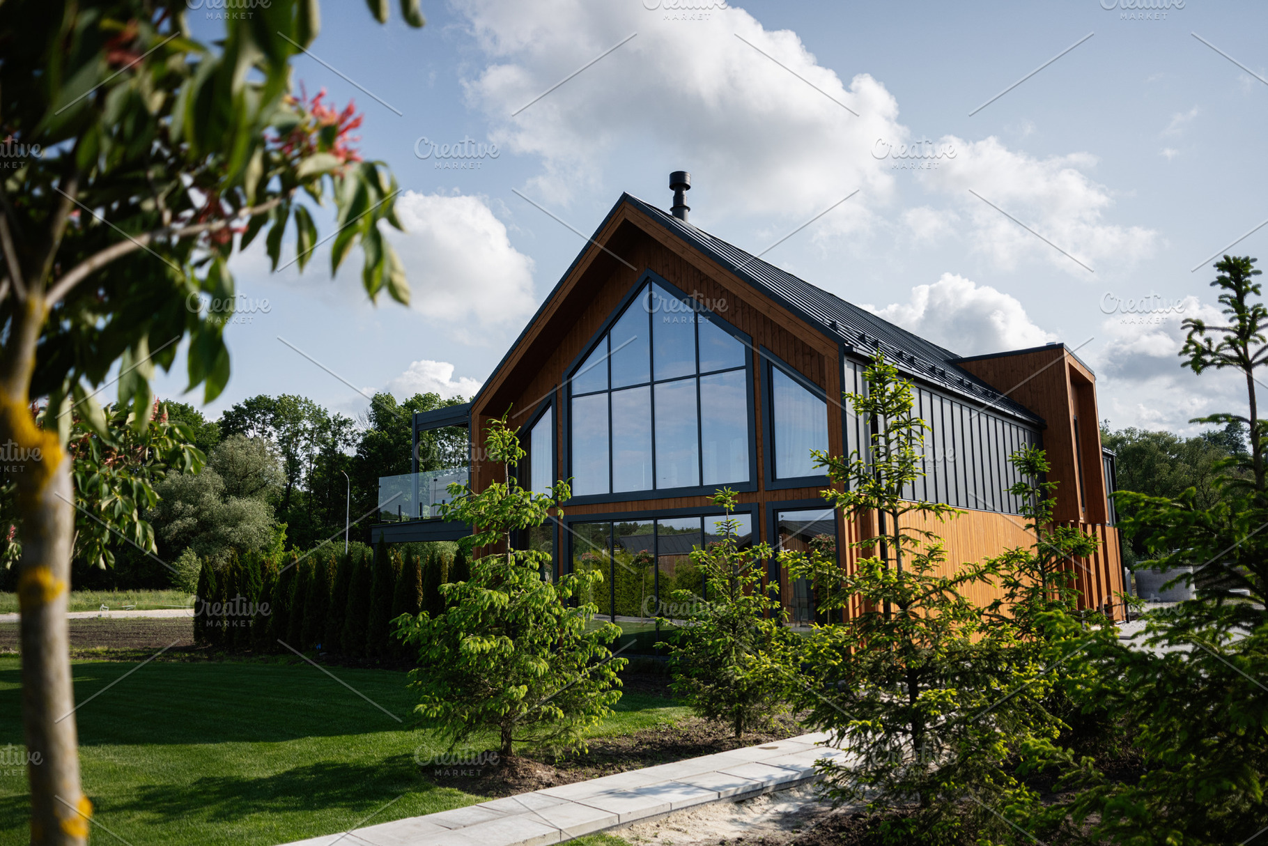 Modern wooden house with large windows surrounded by nature and ...