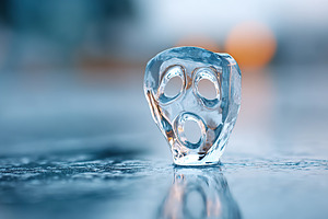 Unique ice sculpture resembling a haunting face displayed in cold setting durin, a Photo by AlyaAnd