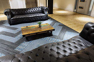 Cozy leather lounge in a modern Manchester lobby with a coffee table and a plan, a Photo by AS photostudio