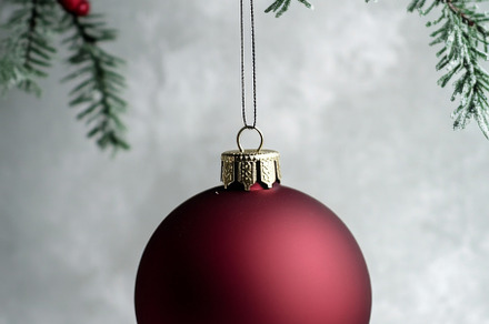 Red Christmas ornament hanging from Christmas tree branch, suita, a Photo by Dvoevnore photos