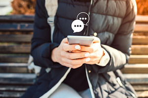 Female hands typing using smartphone with chat icon pop up