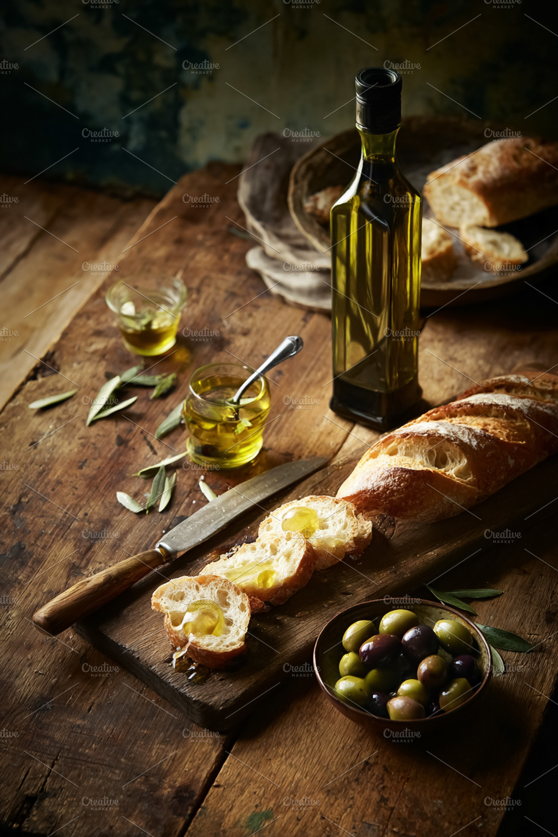 Extra virgin olive oil bottle and olives on a rustic wooden tabl, a Photo by Studio ANNA