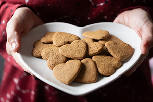 Hands holding a heart-shaped gingerbread cookies, a Food & Drink Photo by etorres69