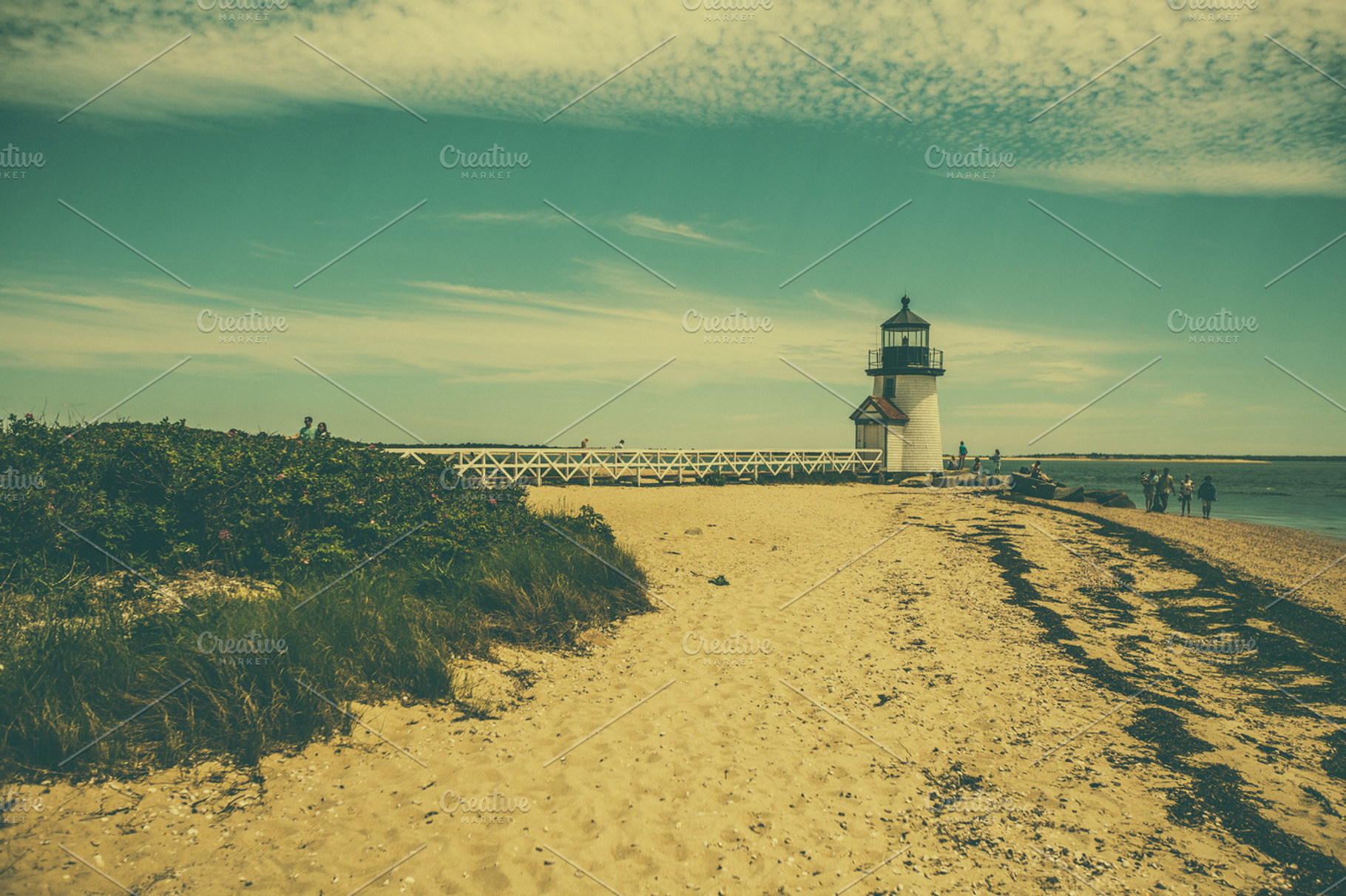 Lighthouse on the beach containing beach, sand, and waves