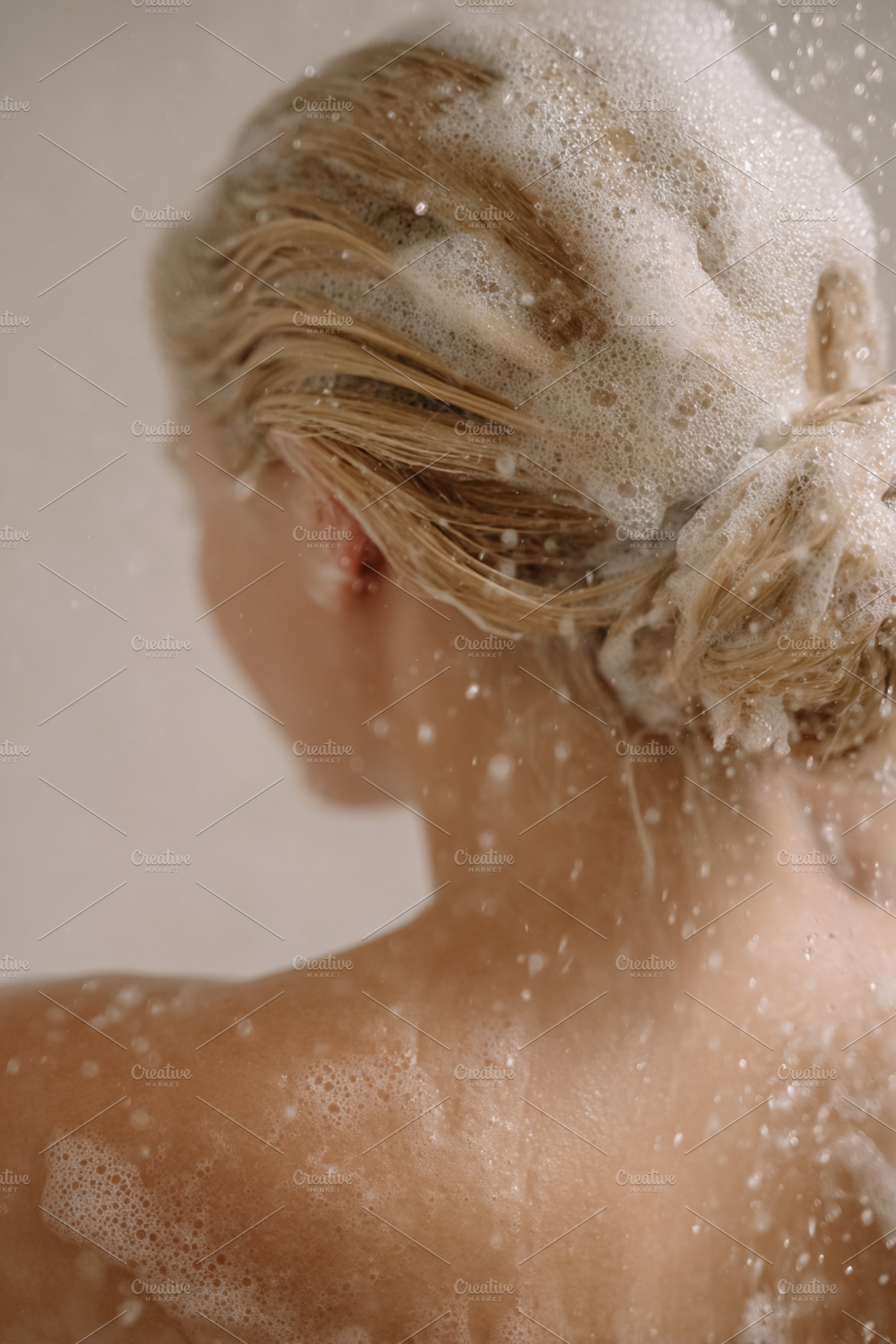 Woman washing blonde hair with shampoo and bubbles, showering for clean hygiene, a Photo by Studio ANNA