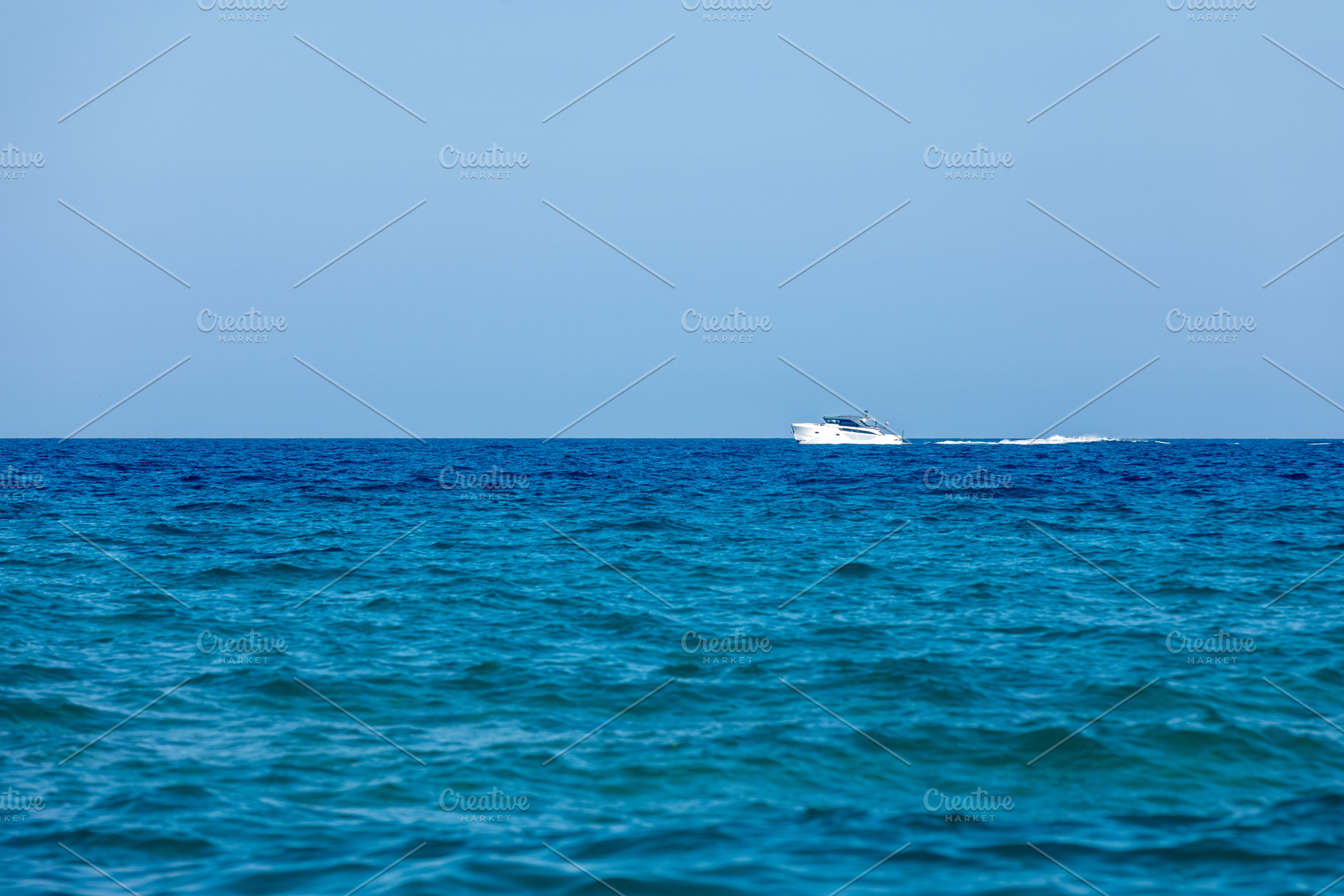 White yacht cruising on a calm blue ocean under clear sky, symbolizing travel,, a Transportation Photo by Ales Munt