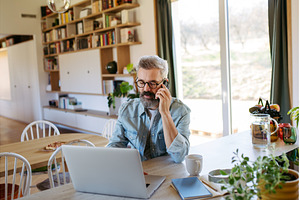Man working from home while on phone, a Person Photo by HalfPoint