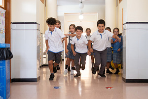 Happy Elementary School Children Running Through School Hallway During Break Ti, a School & Education Photo by etorres69