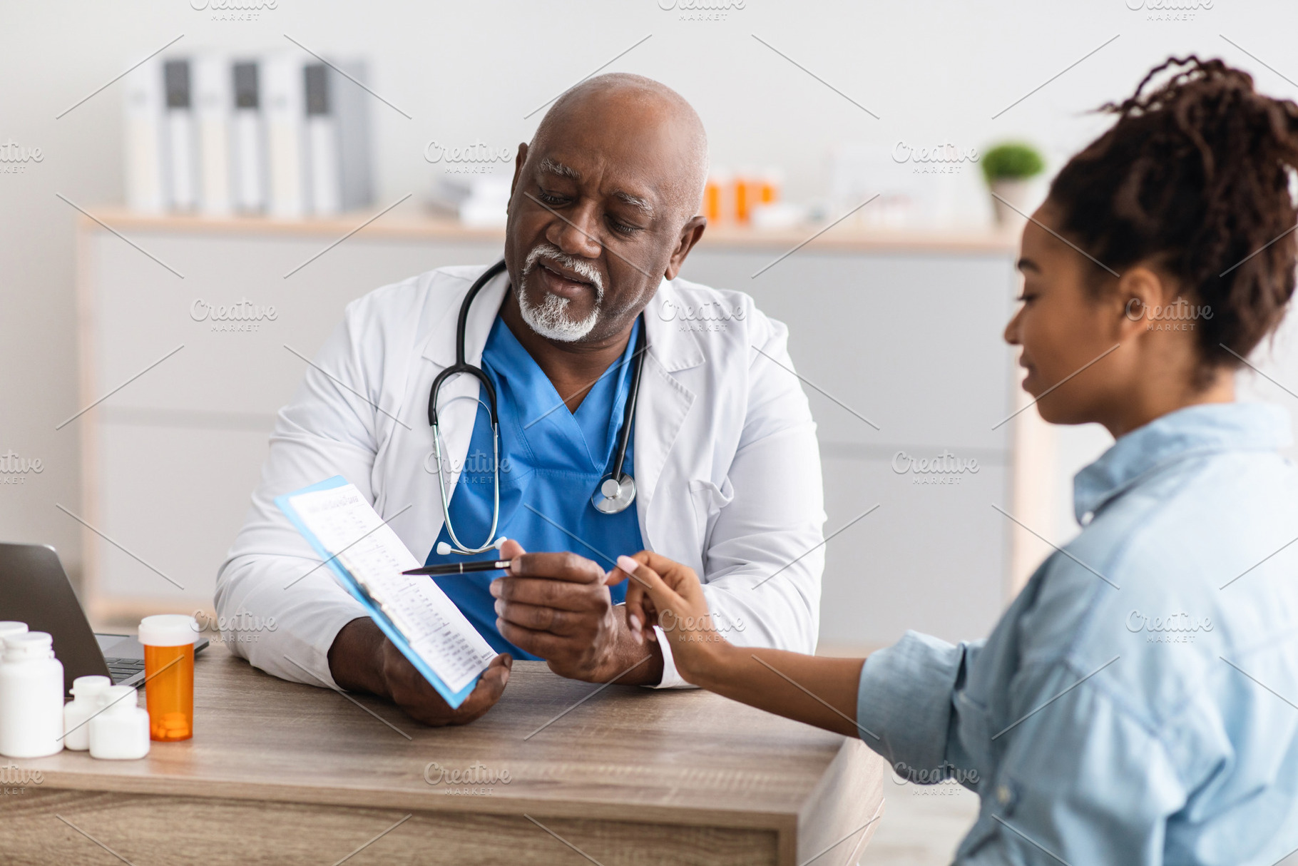 Mature black doctor explaining treatment plan to female patient, a Photo by Prostock-Studio