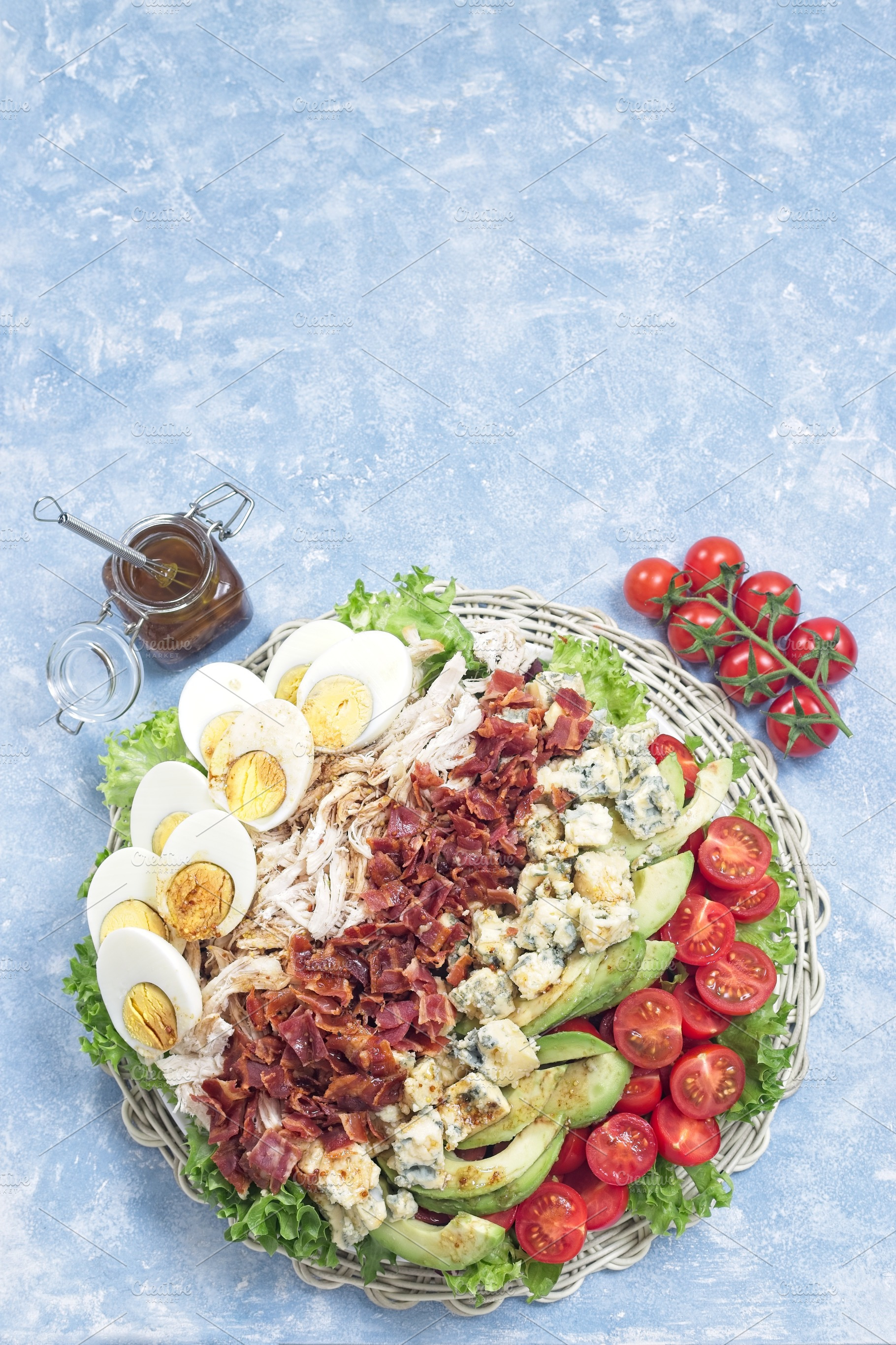 Delicious Cobb salad on a white plate, vertical top view copy space, a Food & Drink Photo by iuliia_n