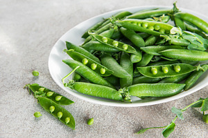 Fresh green peas and pods on white plate, a Food & Drink Photo by Olena Rudo