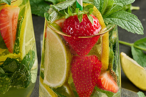 A refreshing drink in a glass with lemon slices, strawberries, f, a Food & Drink Photo by ndanko