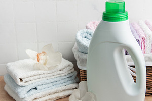 Laundry detergent bottle with fresh clean towels and orchids