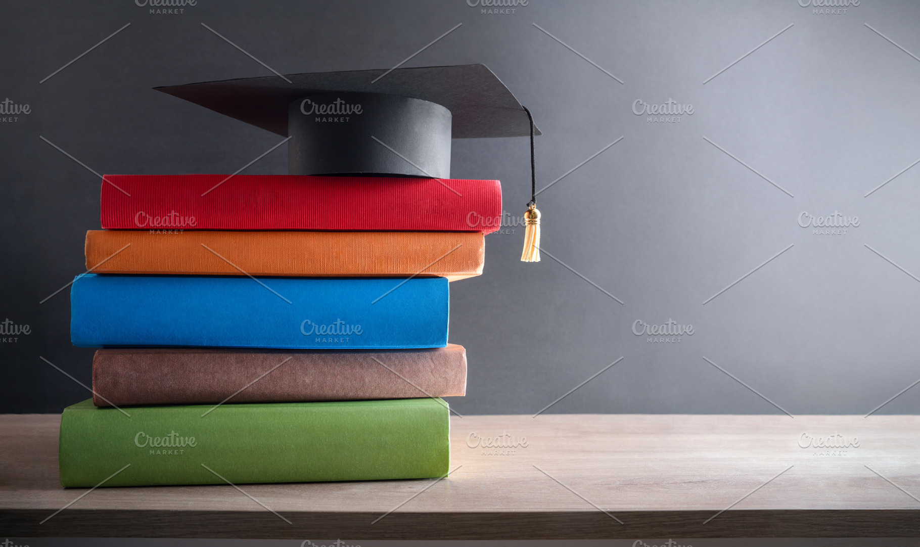 Graduation concept with mortarboard on stack of books on table, a School & Education Photo by Davizro's Market